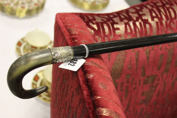 A Horn Handled Ebonised Walking Stick with white metal mount
