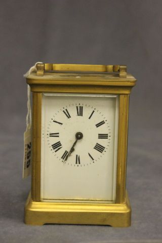 A Brass Carriage Clock with white enamel face and key