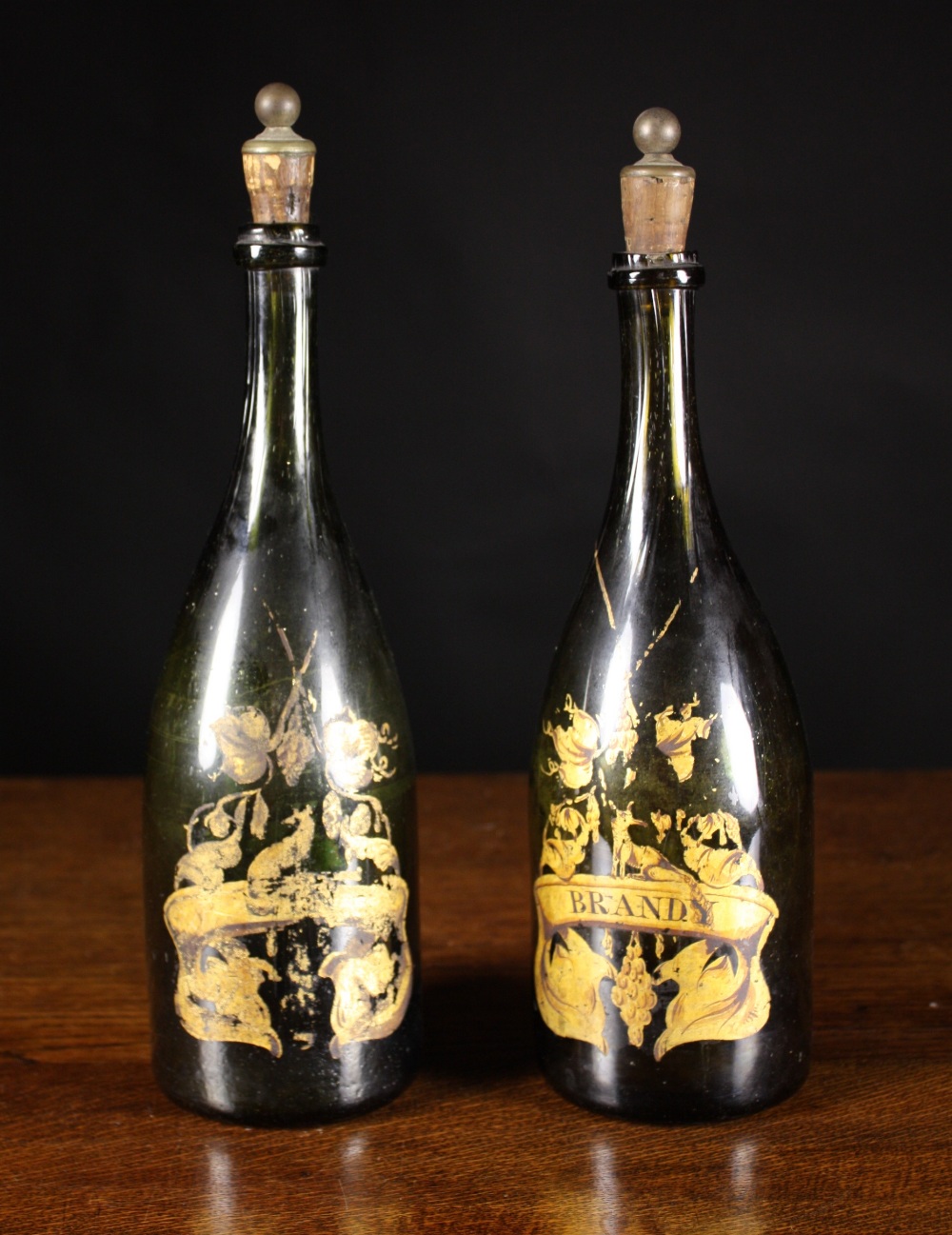 A Pair of Late 18th Century Green Glass Bottle Decanters with kick-up bases and painted gilt