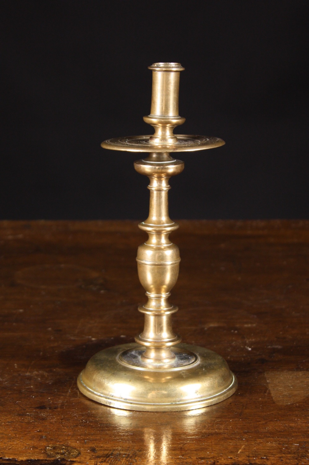 A Brass Candlestick Circa 1700.  The candle nozzle screwing into a ring-turned drip pan and