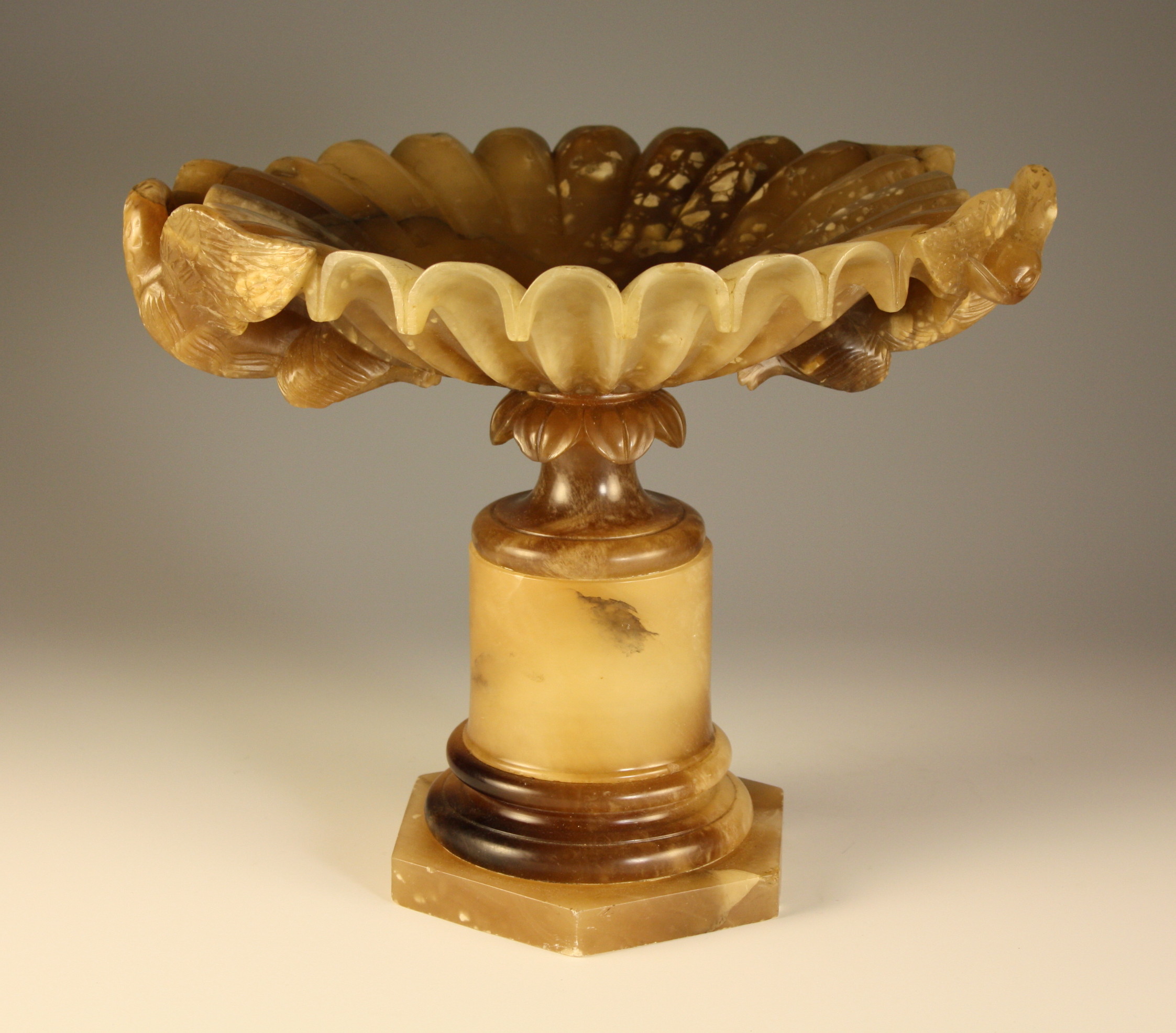 A Carved Alabaster Tazza.  The shallow fluted bowl having a scalloped edge and swan head handles