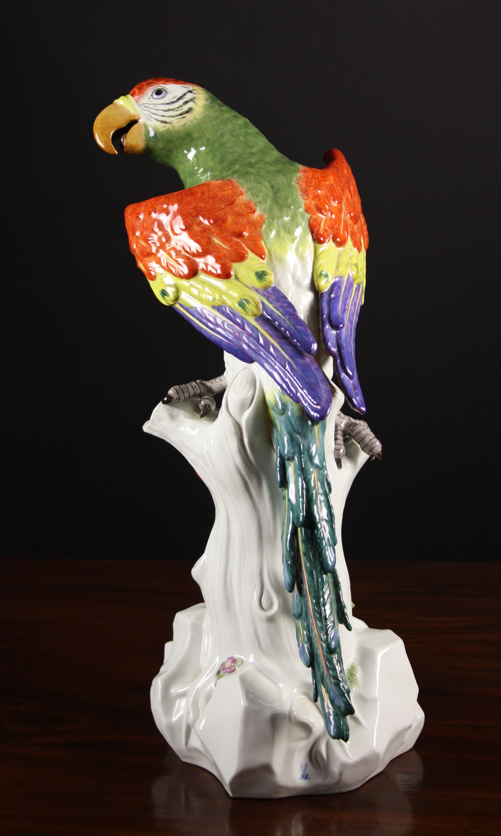 A Large Meissen Figure of a Scarlet Macaw with colourful plumage perched on an encrusted tree