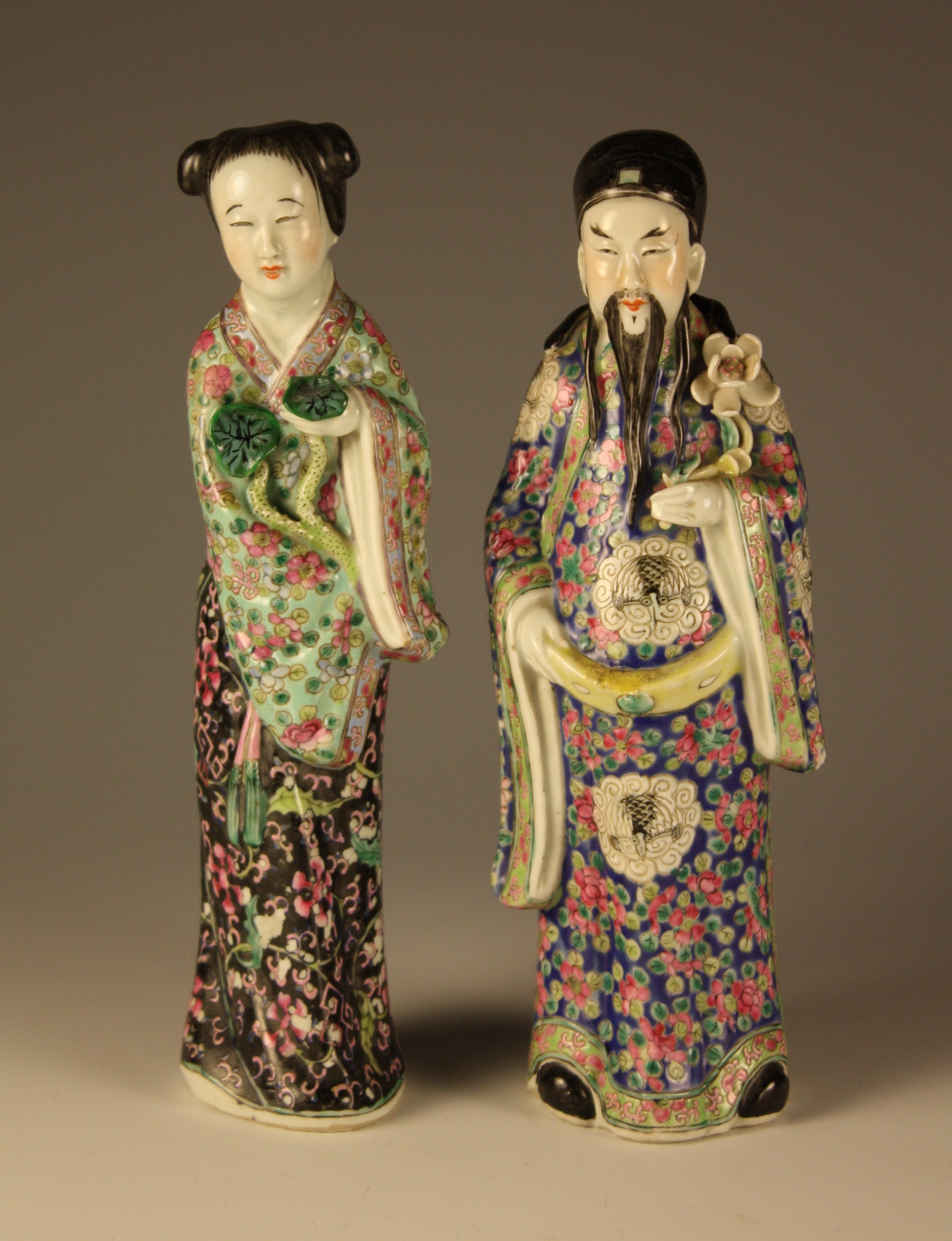 A Pair of Oriental Ceramic Figures of Dignitaries: a man & woman dressed in decorative polychrome