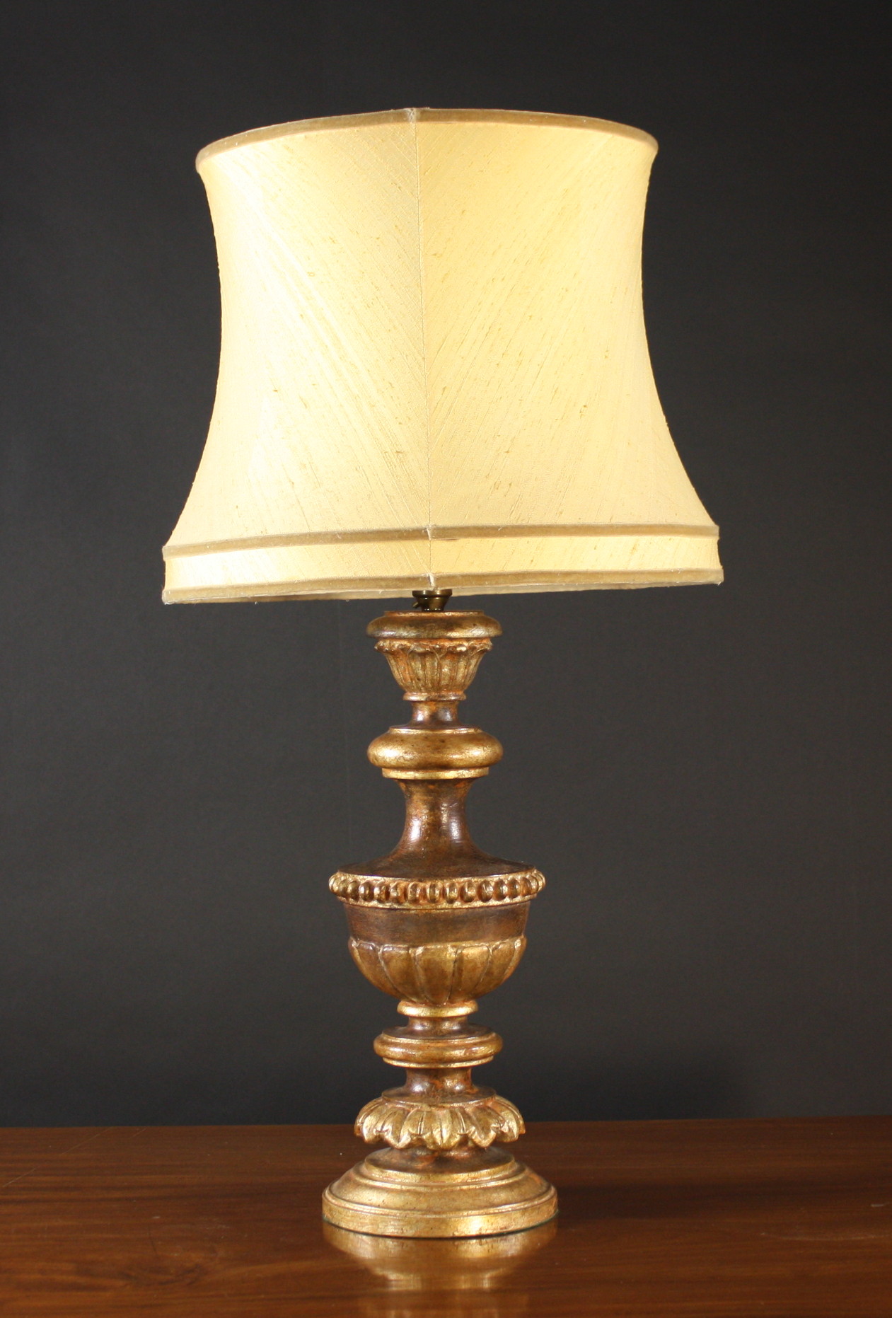 A Carved & Painted Giltwood Table Lamp with cream silk shade. The lamp base 17½ ins (44 cms) in