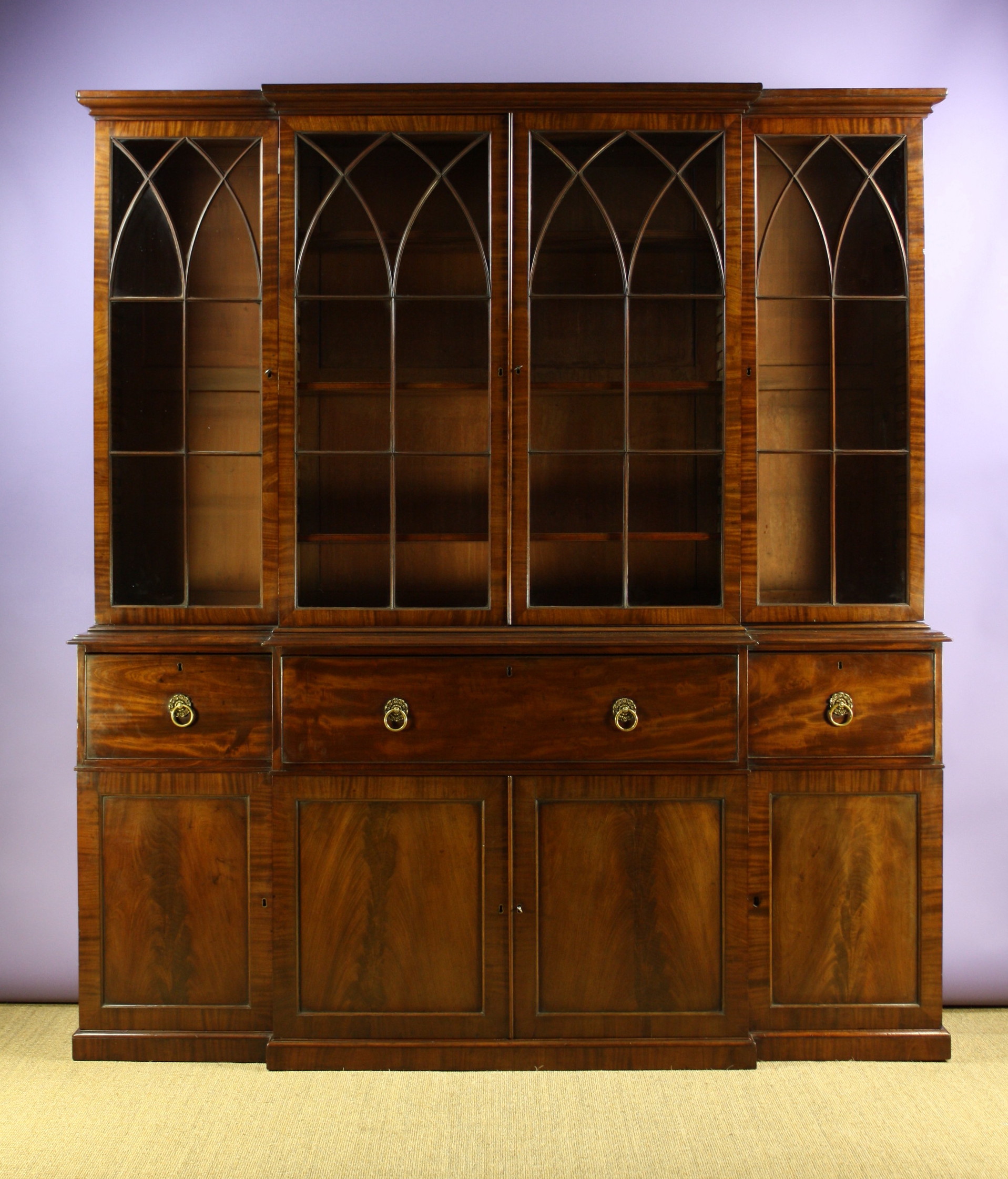 A Fine Regency Mahogany Break-front Secretaire Bookcase.  The upper section having four glass