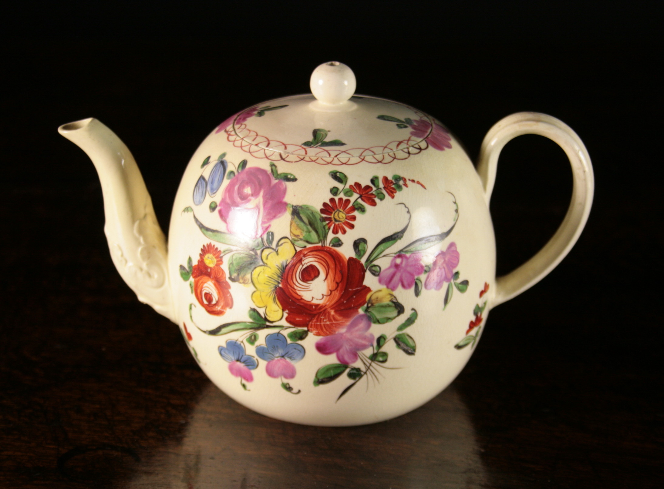 An 18th Century Creamware Teapot hand decorated with floral bouquets, 5¼ ins (13.5 cms) in height.