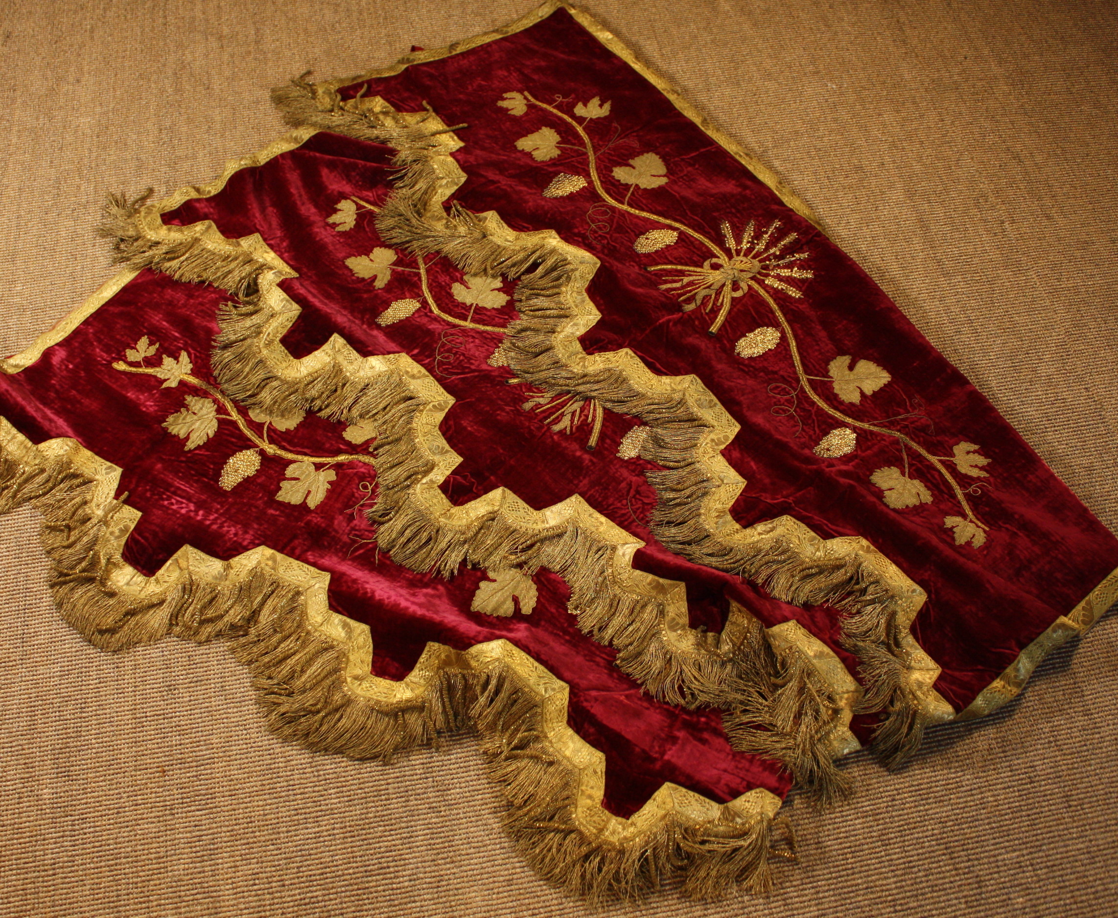 A Set of Three Crimson Silk Velvet Pelmets embroidered & appliquéd with scrolling vines bearing