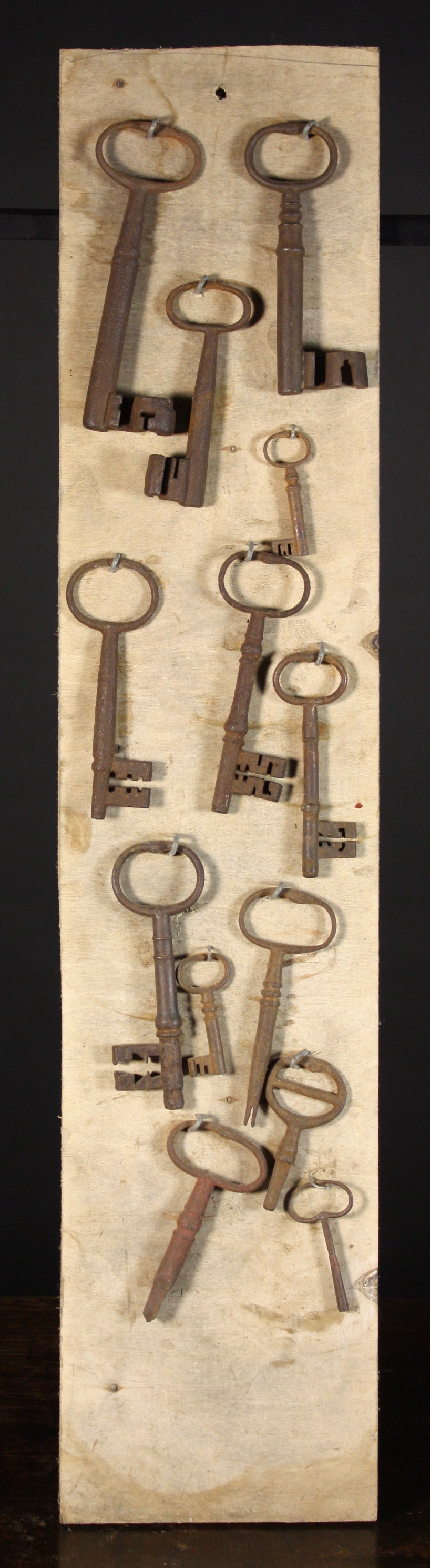 A Collection of Antique Keys mounted onto a board and ranging in lengths from 6¼ ins to 2¼ ins (16