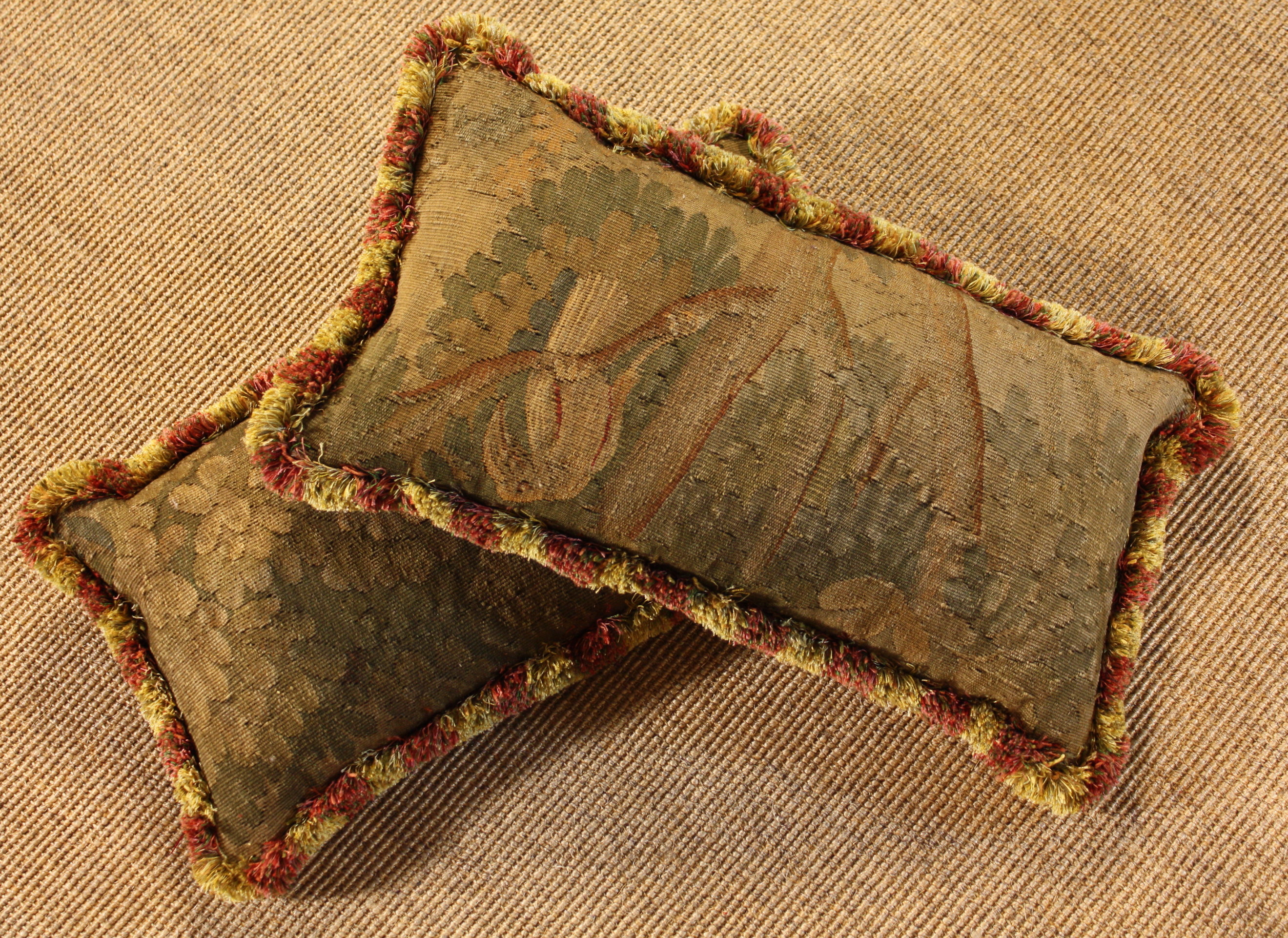 A Pair of Tapestry Cushions.  The 18th century covers woven with leaves; one with a bird and edged