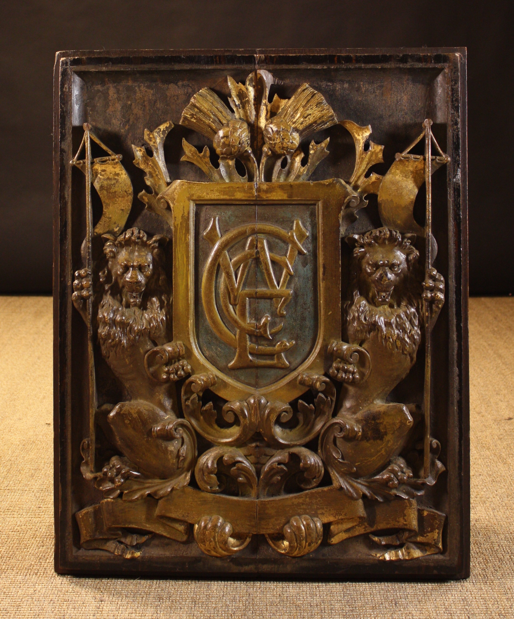 An Early 18th Century Carved & Polychromed Armorial Plaque.  The central monogramed shield amidst