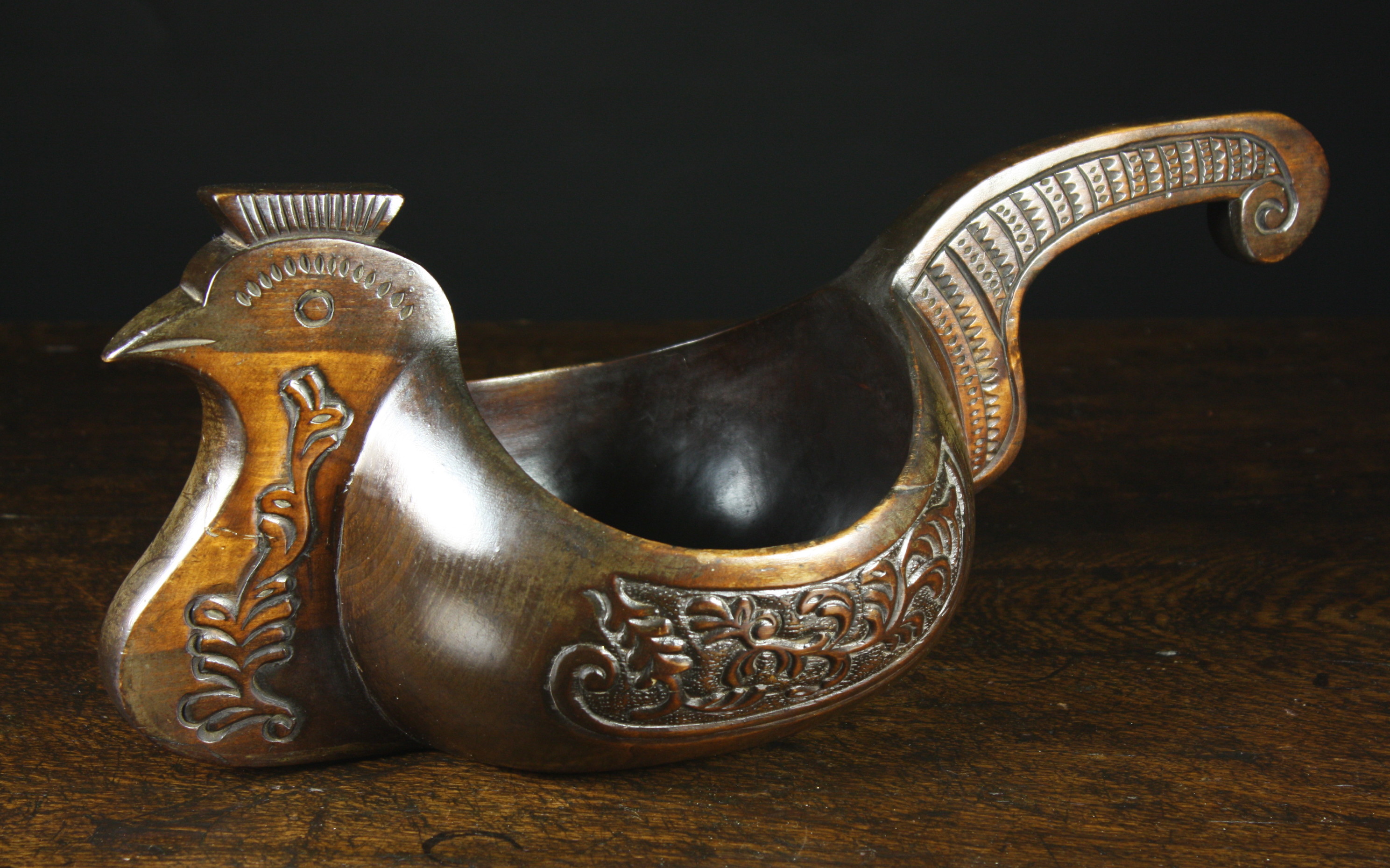 A 19th Century Scandinavian Carved Wood Ale Hen. The sitting bird carved with panels of stylized