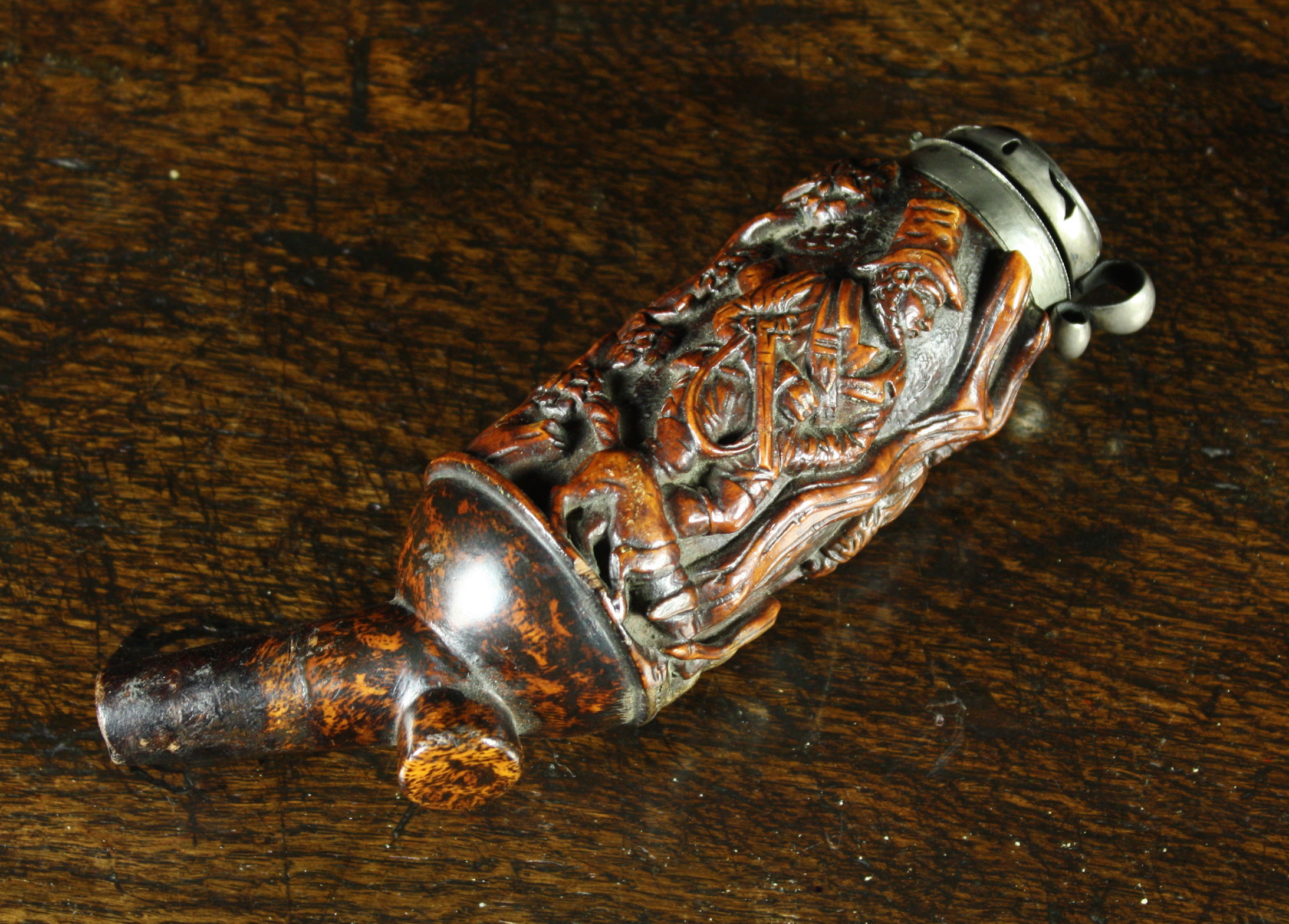 An 18th Century Fruitwood Pipe Bowl richly carved with hunting scenes and having a silver metal