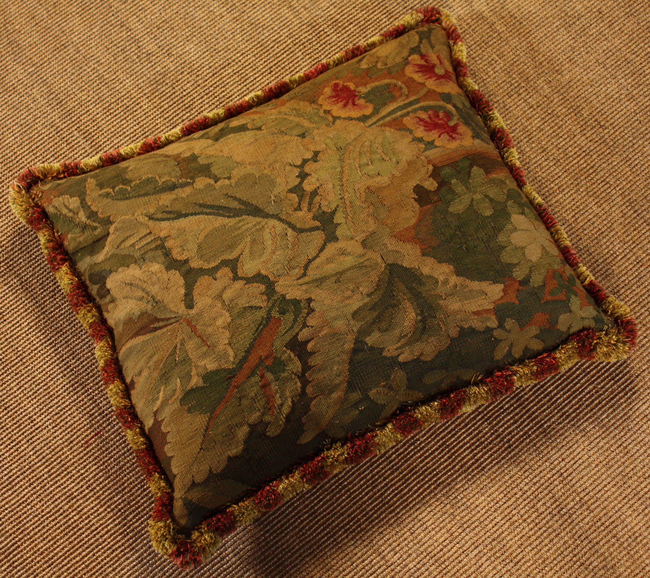 A Large feather-filled Tapestry Cushion.  The 18th century Gobelin cover woven with foliage and