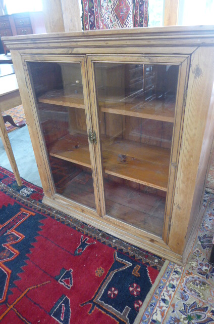 A 19th century waxed pine bookcase with two glazed doors 107cm wide x 110cm high