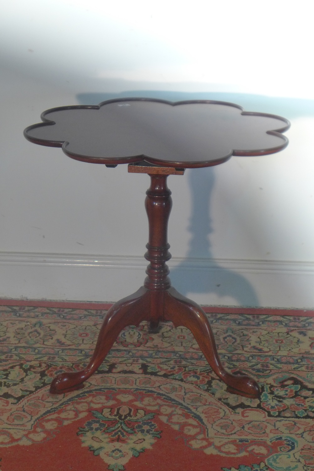 A small mahogany reproduction (1990`s) table on pedestal - table top tilts vertically