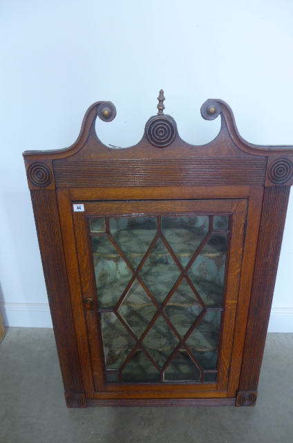 A good quality Georgian oak corner cabinet with a swan neck pediment above a single astragal