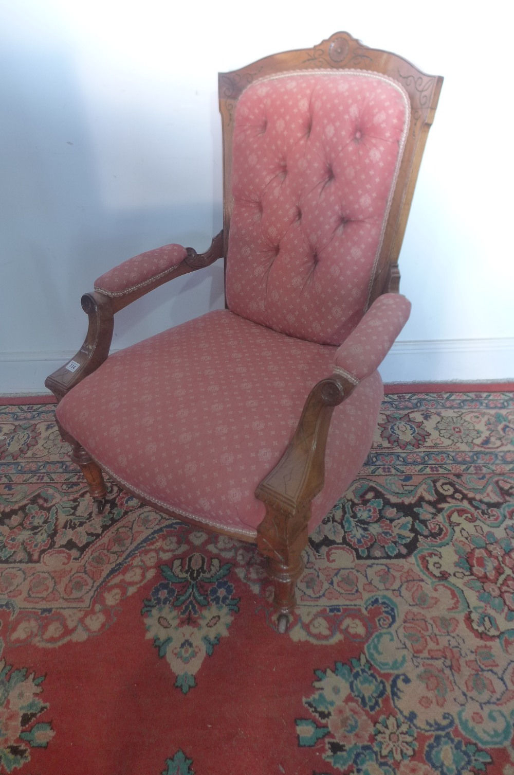 A Victorian walnut button back open armchair on turned and fluted legs