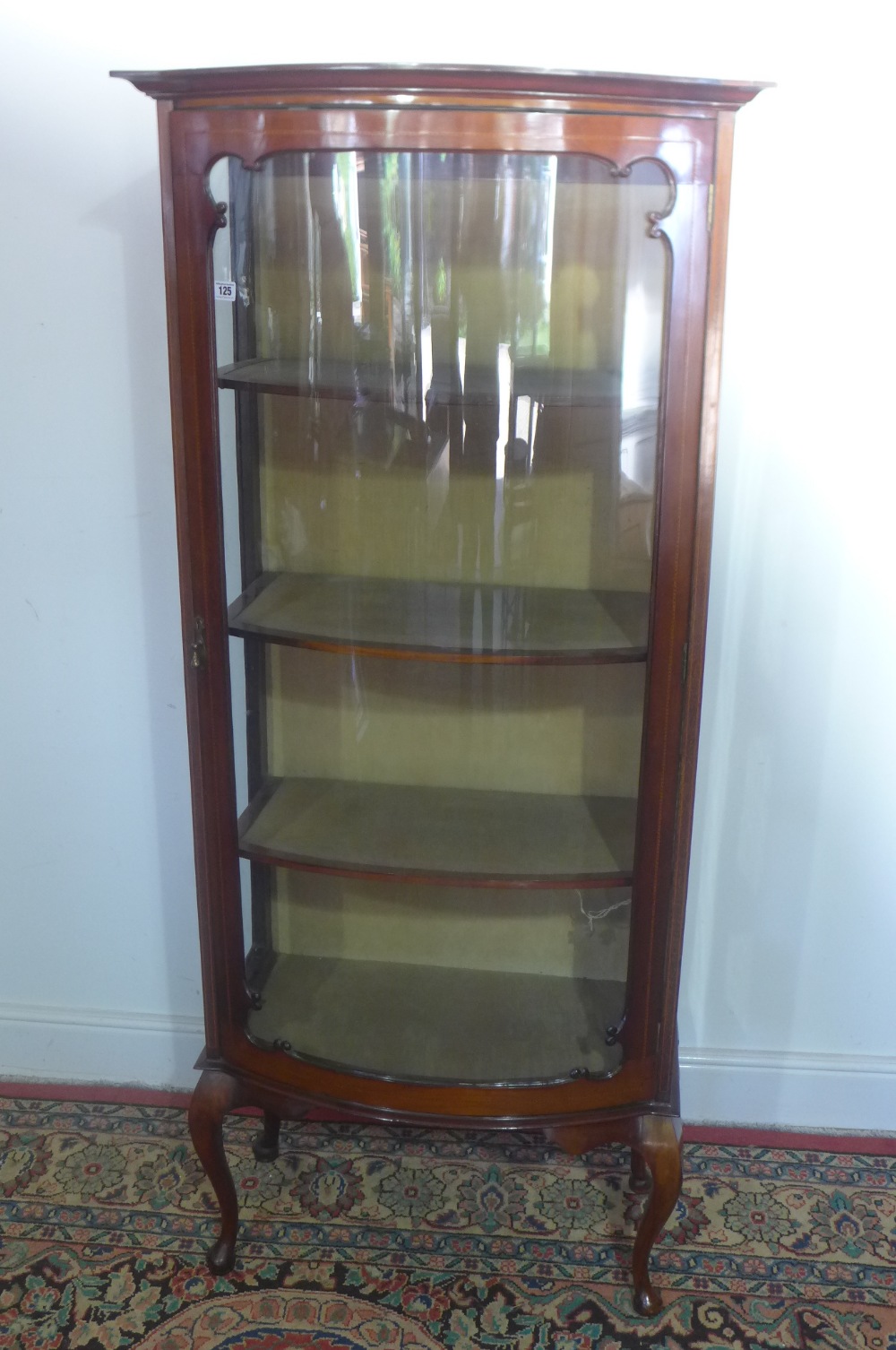 An Edwardian mahogany bowfront display cabinet standing on cabriole legs - glass missing to one side