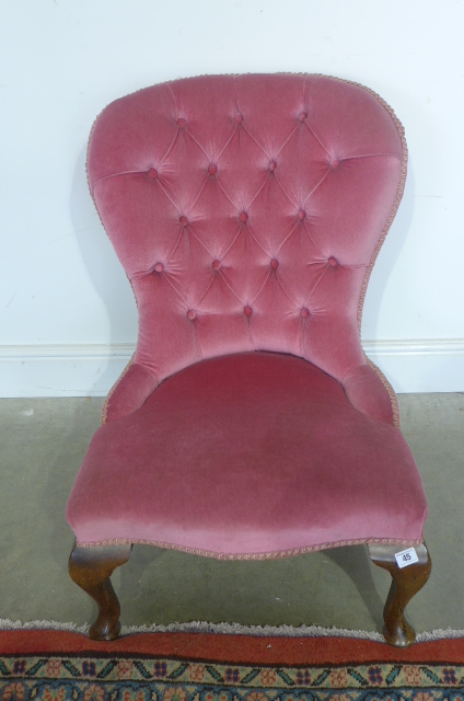 A pink button back upholstered nursing chair on cabriole legs