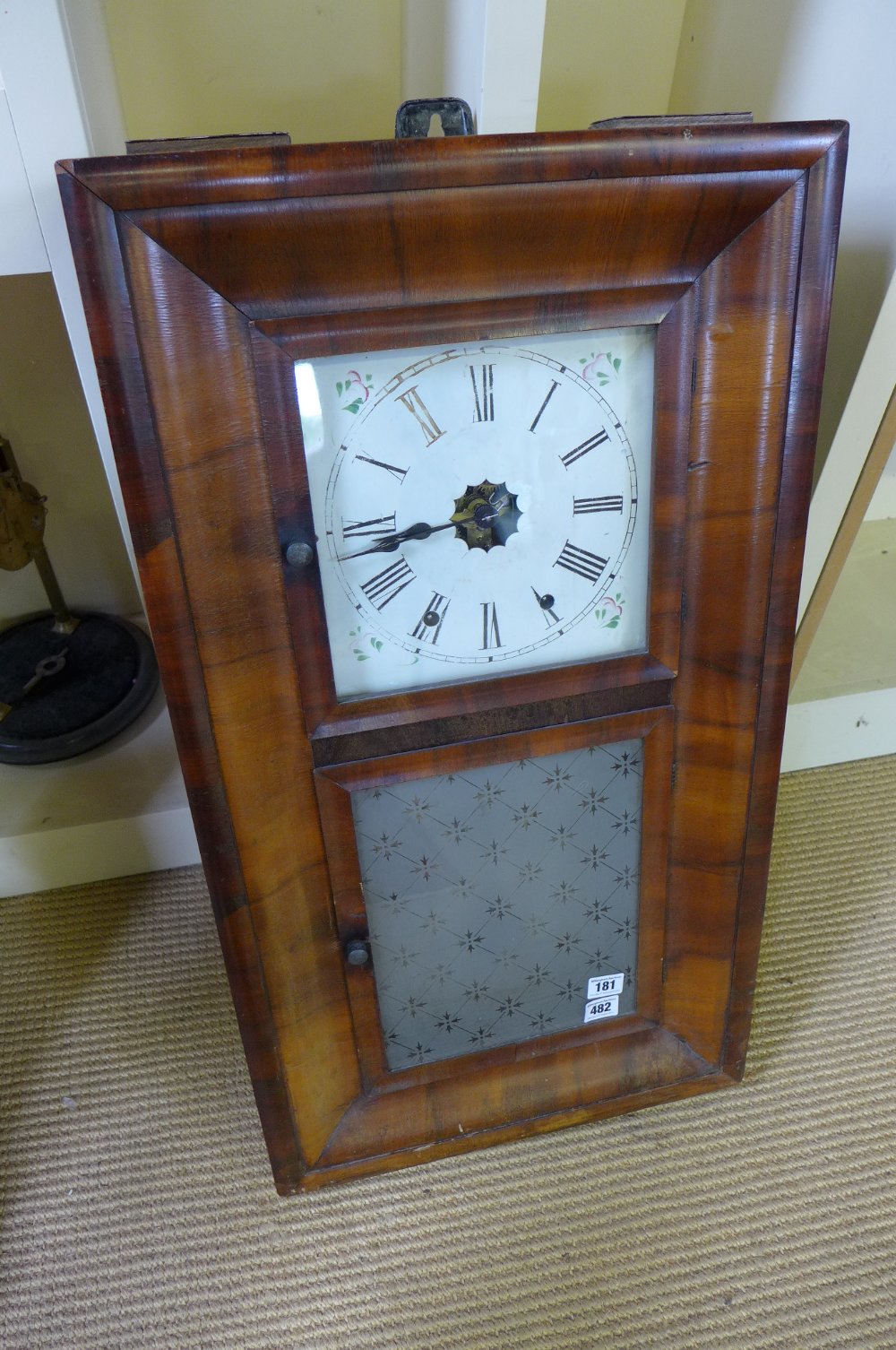 An American wall clock with eight day movement walnut veneered case with cushion moulding`s - has