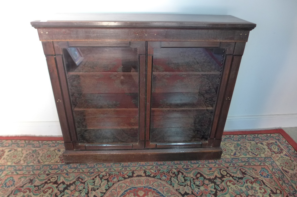A late Victorian oak and inlaid dwarf glazed two door bookcase 104cm high x 121cm x 30cm