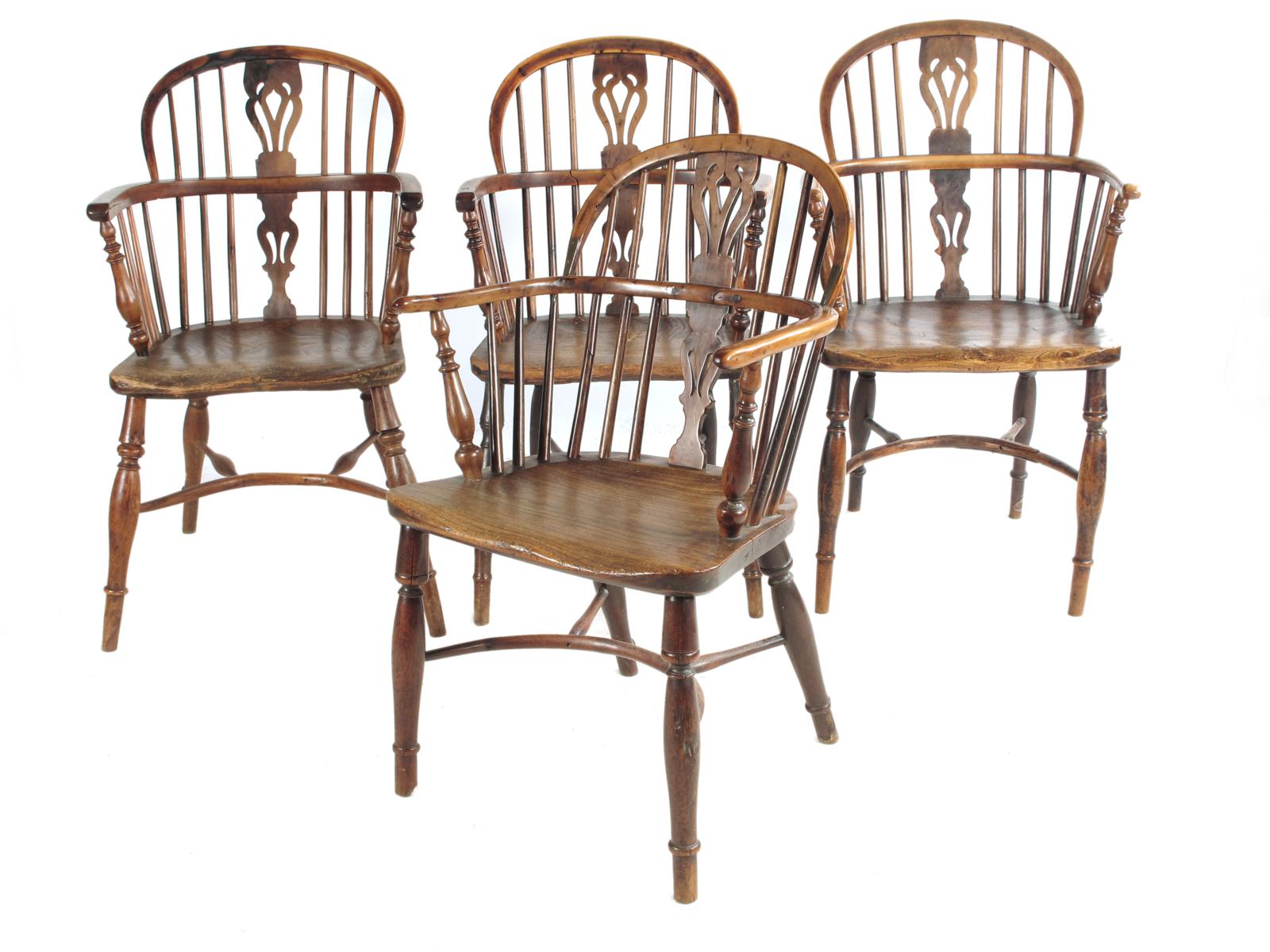 A set of four similar 19th century yew low back Windsor armchairs, each with a pierced splat back to