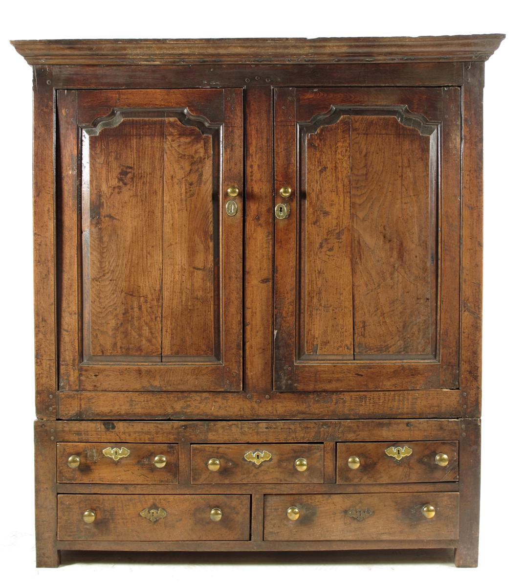 An oak cupboard on stand, with a later cornice above a pair of fielded oak panel doors revealing