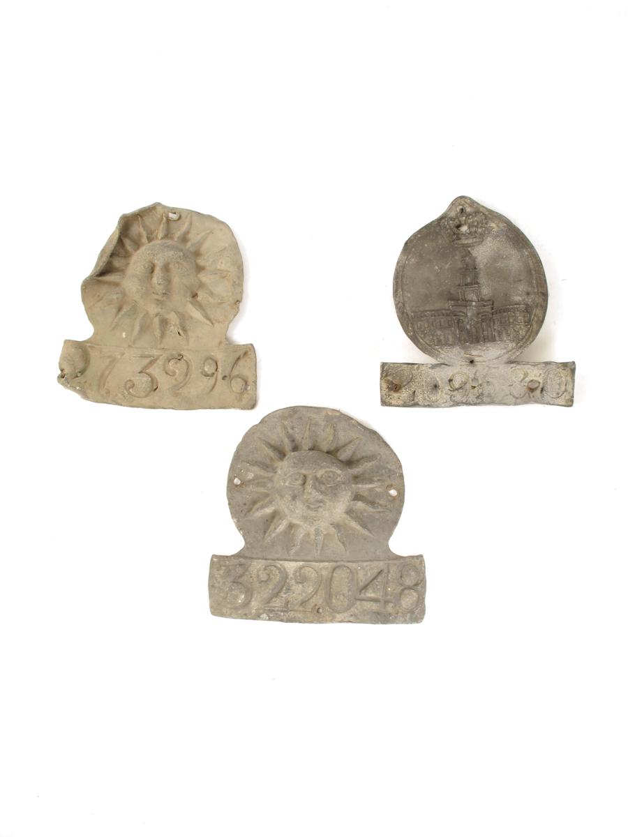 Three lead fire marks, one for Royal Exchange Assurance, numbered `209580`, 7in (17.7cm) high and