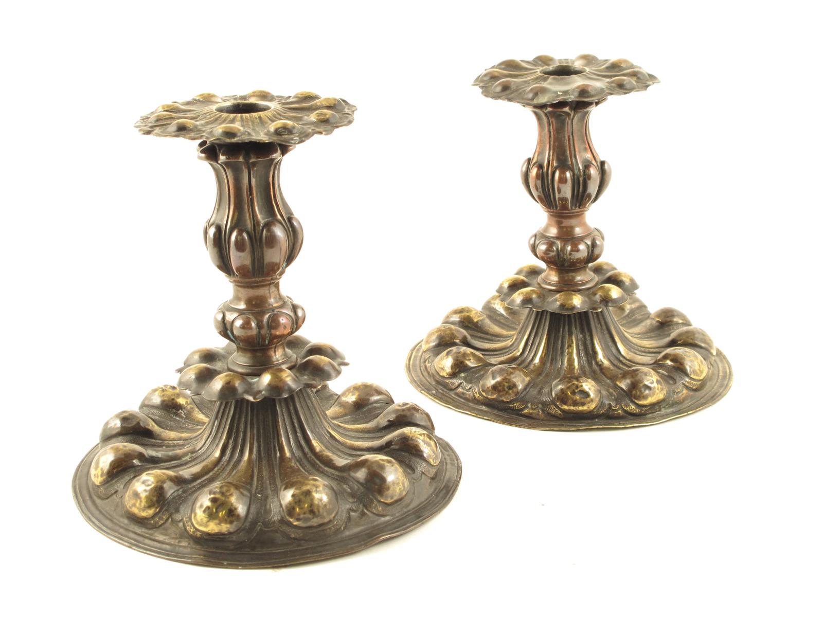 A pair of Italian Baroque brass and copper lobed candlesticks, with detachable nozzles, late