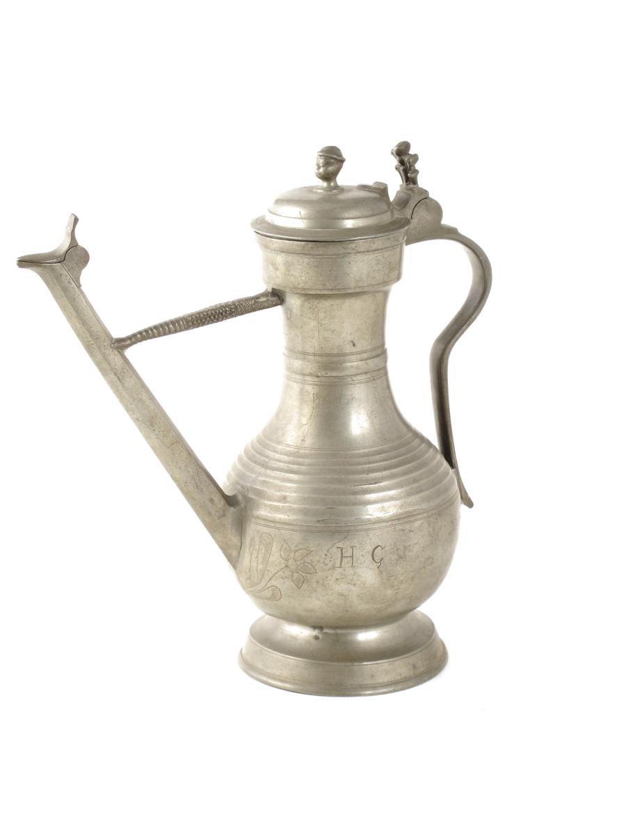 An 18th century Swiss pewter lidded flagon or stegkanne, the body decorated with wrigglework flowers