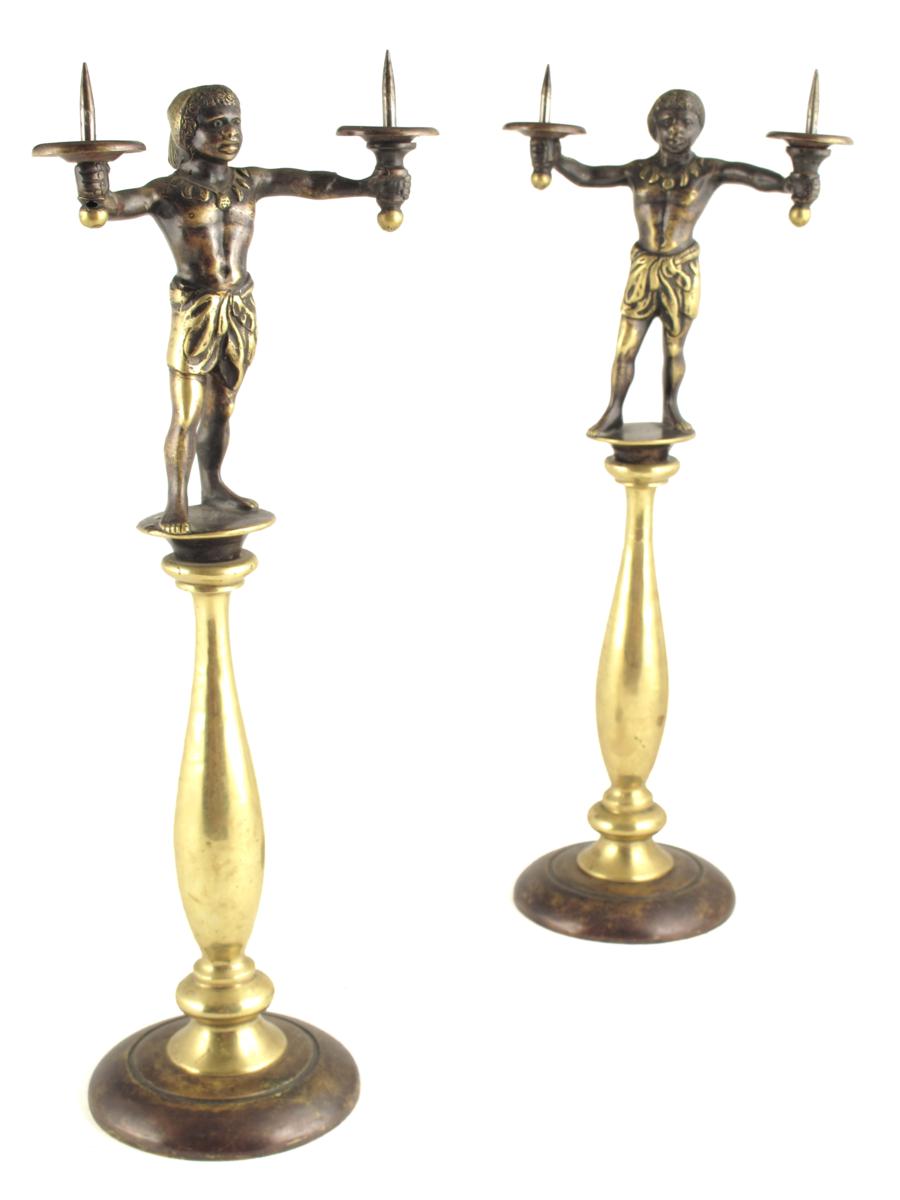 A pair of polished and patinated bronze figural candlesticks, each with a blackamoor figure