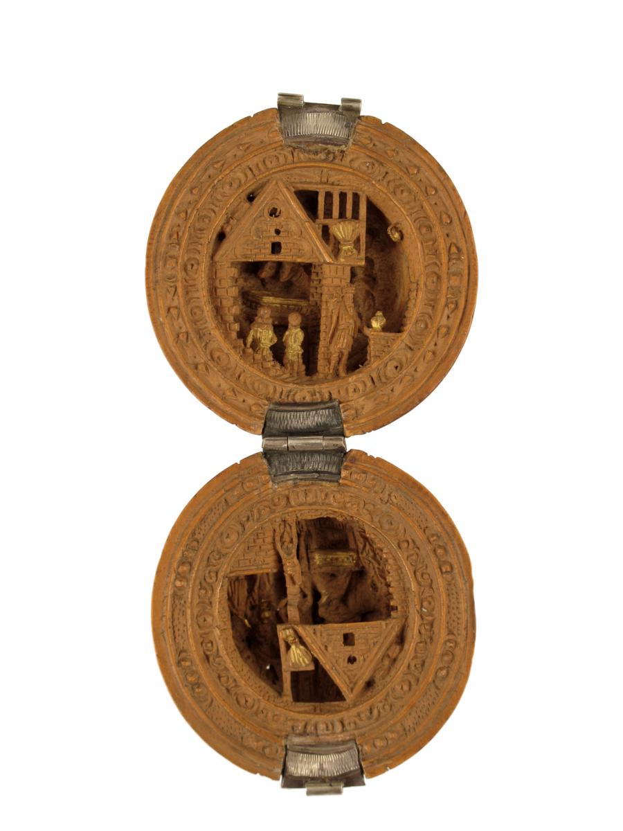 A carved wood rosary bead or prayer nut in 17th century style, hinged revealing parcel gilt nativity