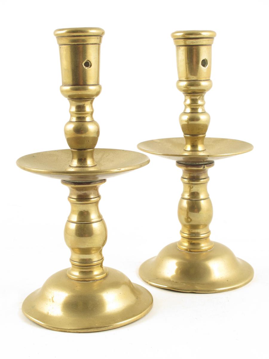 A pair of Dutch brass `Heemskerk` candlesticks, each with an ejector hole to turned stems and a