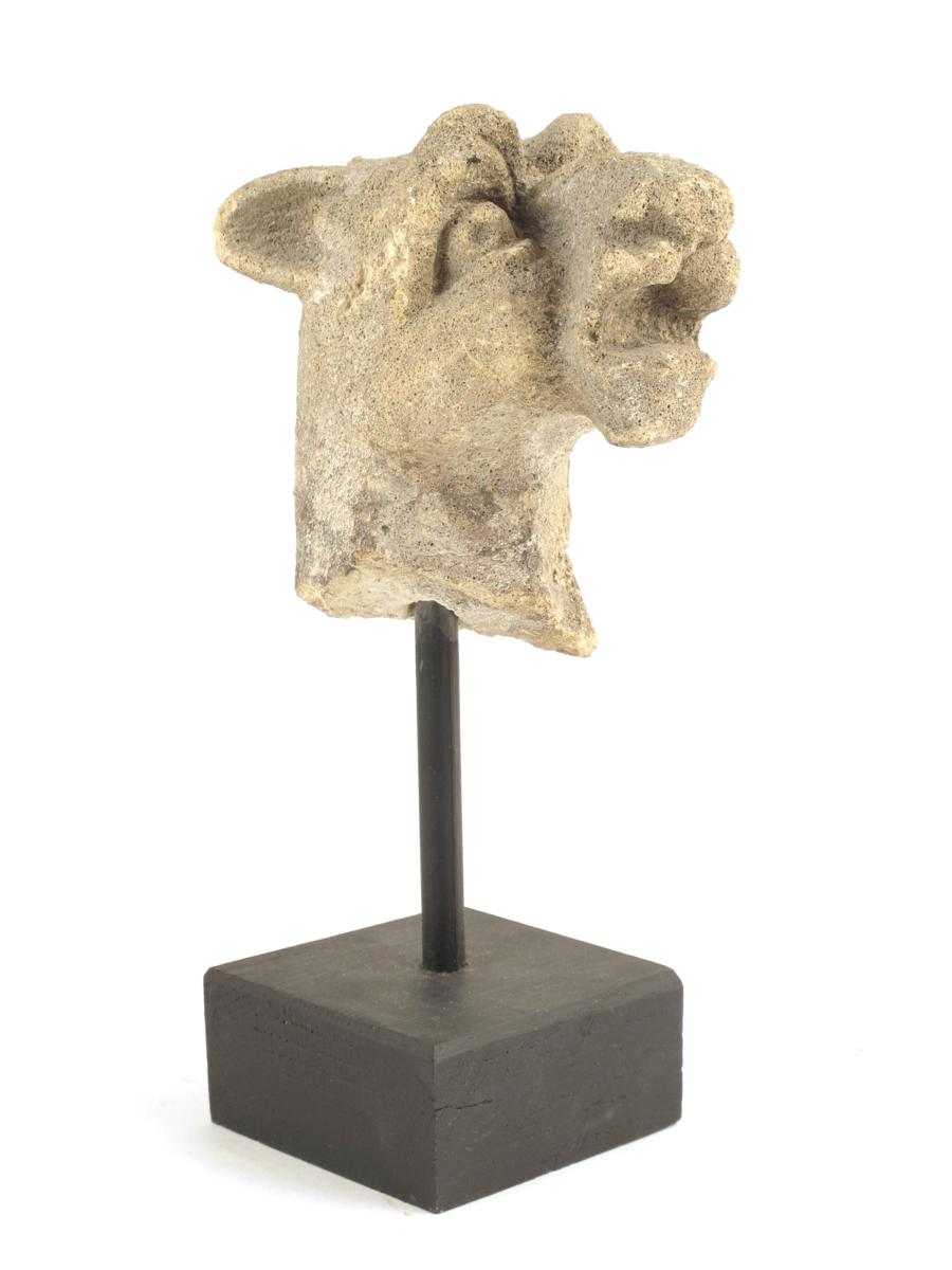 An early English stone head of a stylized lion, 4?in (10.7cm) high, mounted on a modern stand.