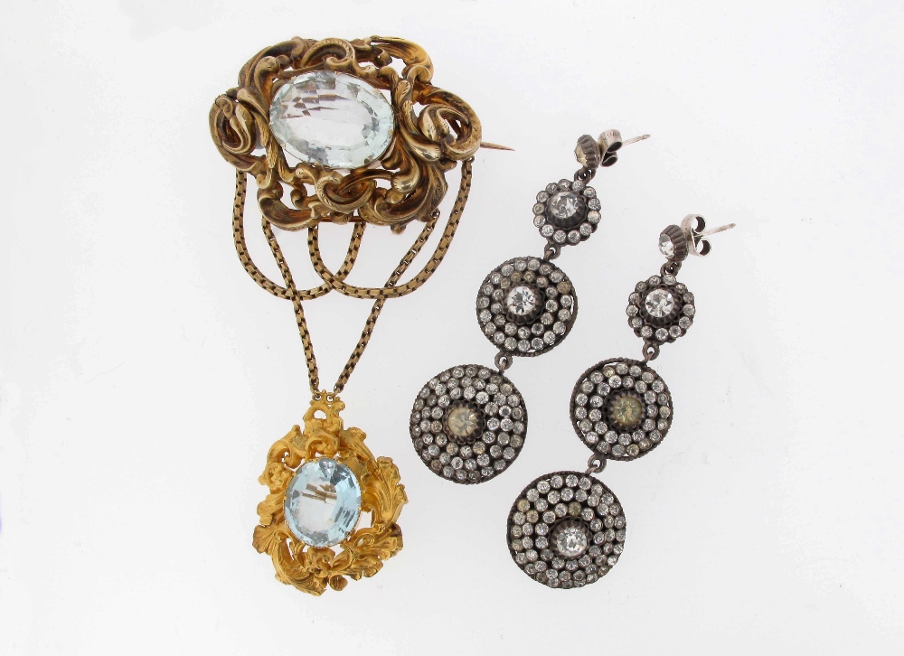 A Victorian aquamarine mounted gold brooch, the foliate scroll mount suspends gold chain festoons