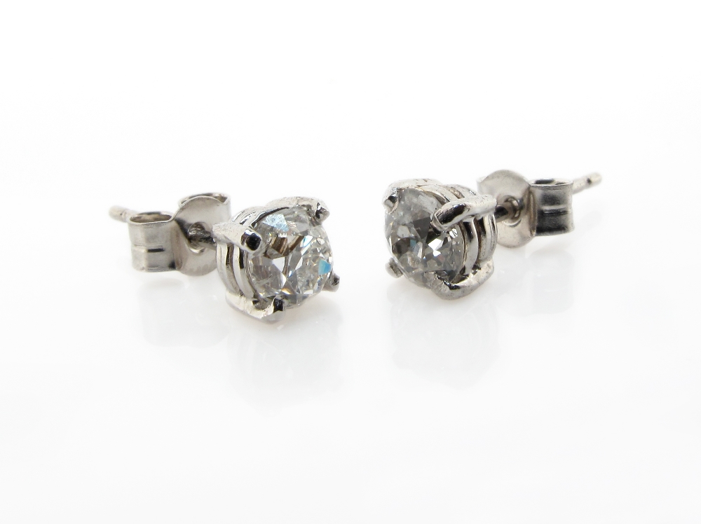 A pair of diamond stud earrings, the old circular cut diamonds are set in white gold.