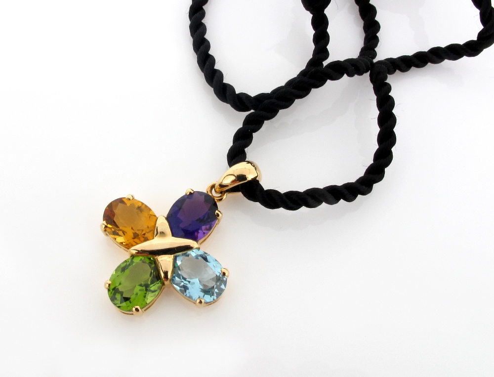 A gold quarterfoil pendant, mounted with an oval shaped amethyst, blue topaz, peridot and citrine,