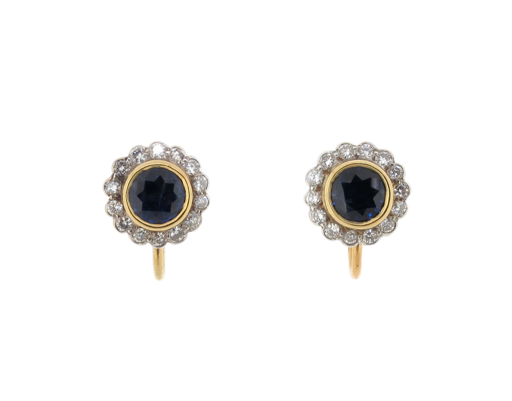 A pair of sapphire and diamond cluster earrings, the circular cut sapphires are set within a