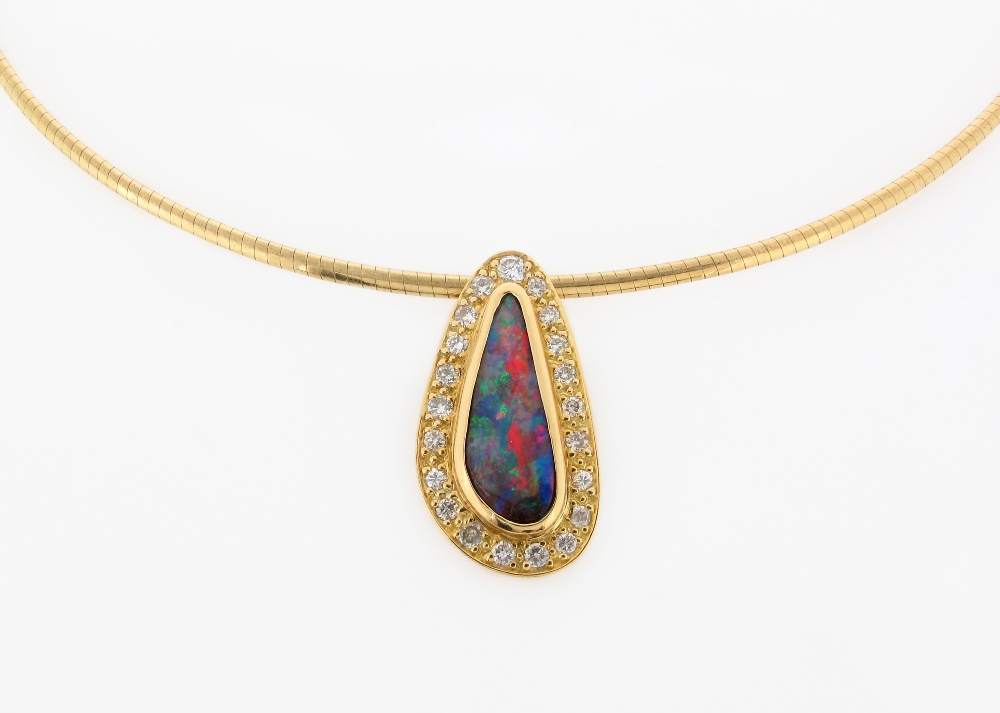 A boulder opal and diamond pendant, of abstract form and set in yellow gold within a surround of