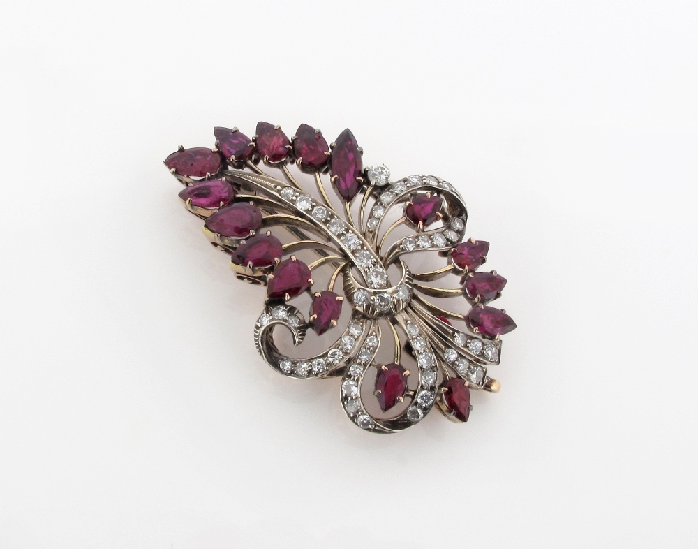 A ruby and diamond foliate gold brooch, the stylised ruby spray tied with a circular cut diamond set