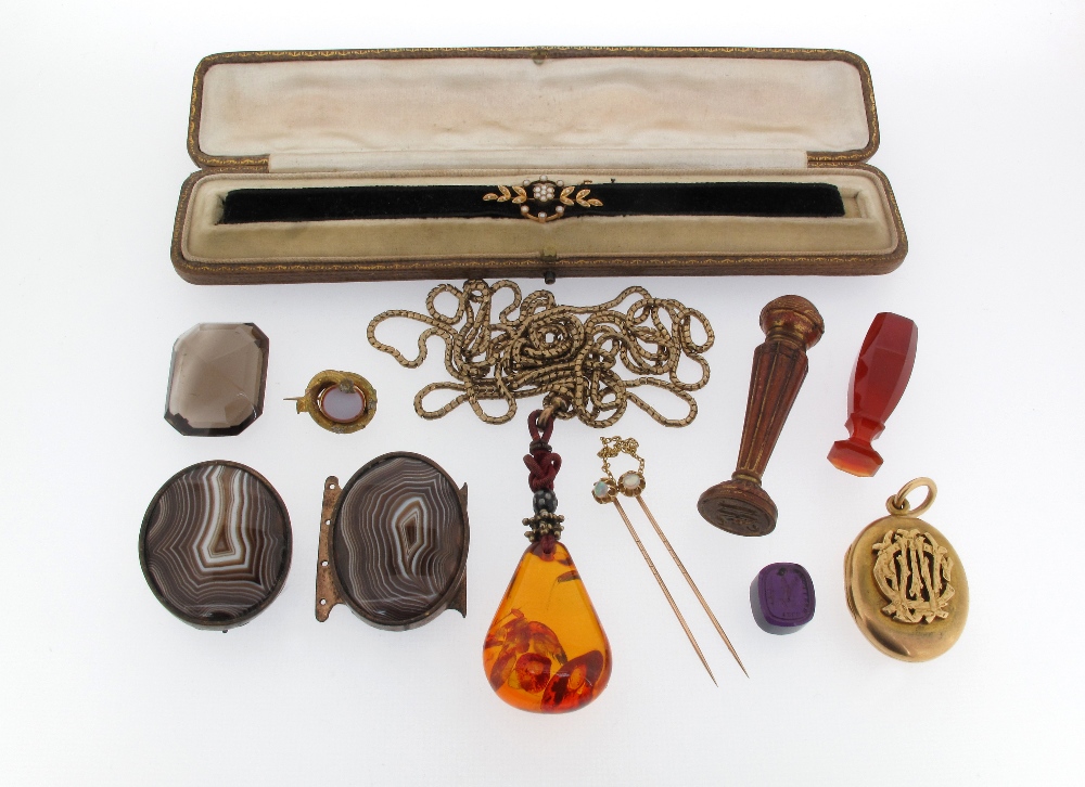 A Victorian gold locket pendant applied with cipher, a carved red agate seal, a large emerald cut