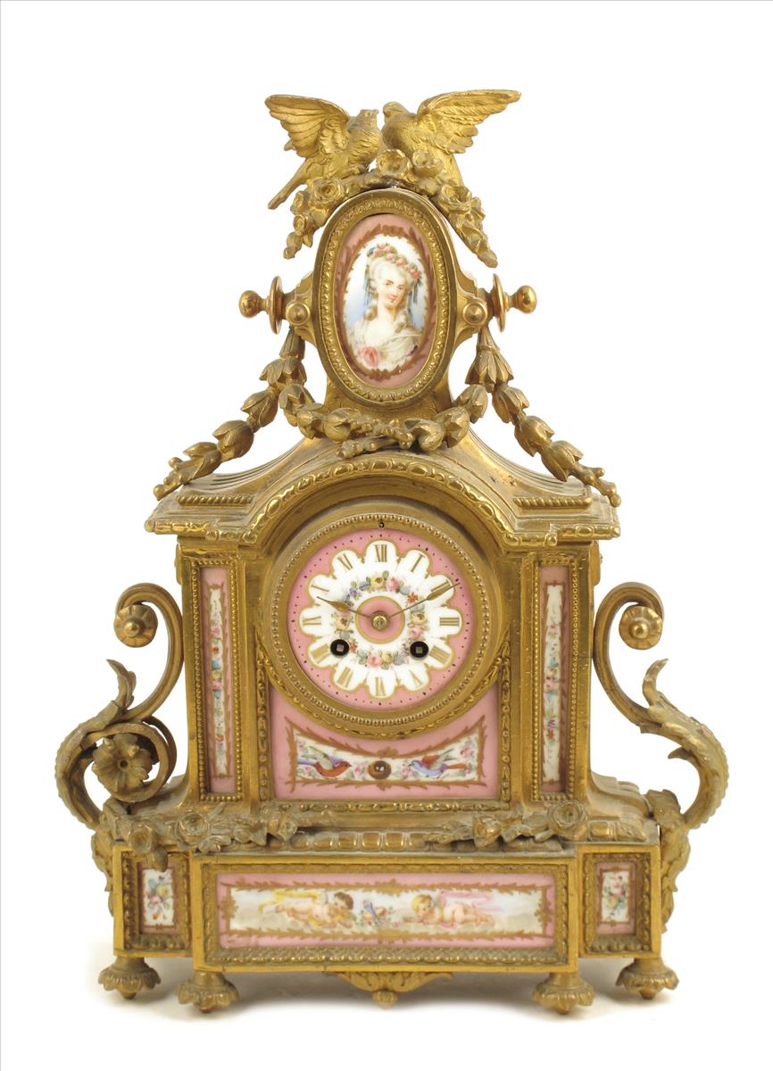A porcelain mounted gilt spelter mantel clock, striking movement by Japy Freres, in a break arch