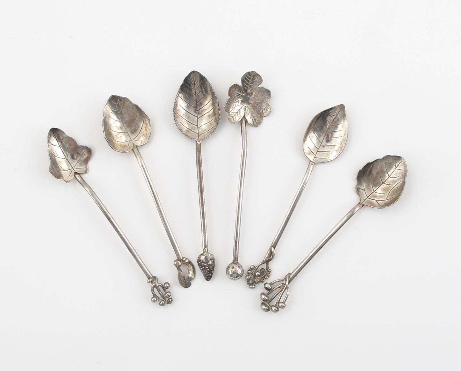 A set of six Aesthetic Movement silver teaspoons, each with leaf shape bowl and berry/seed terminal,