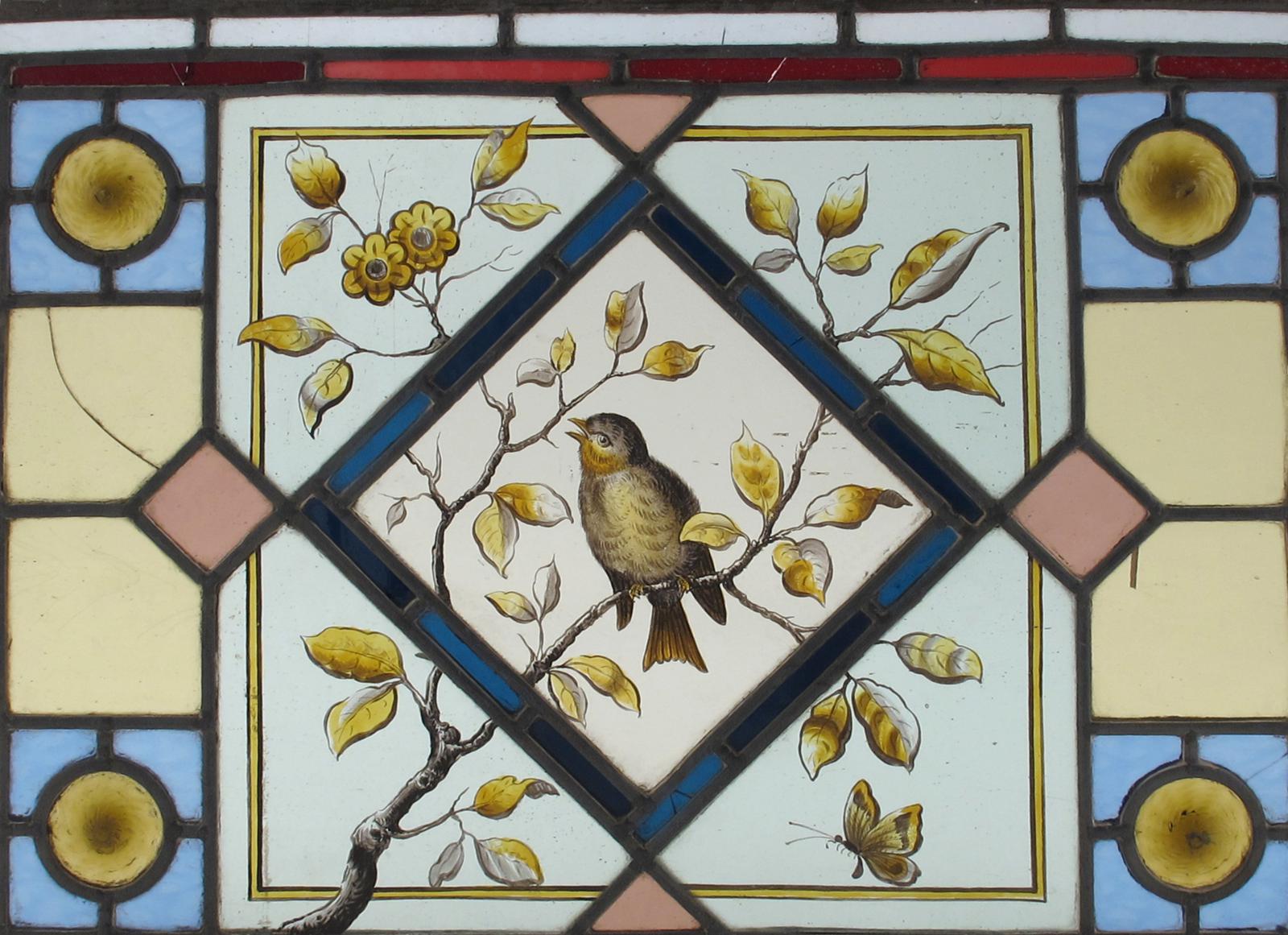 An Aesthetic Movement stained glass window, rectangular, painted with a bird perched amongst foliage