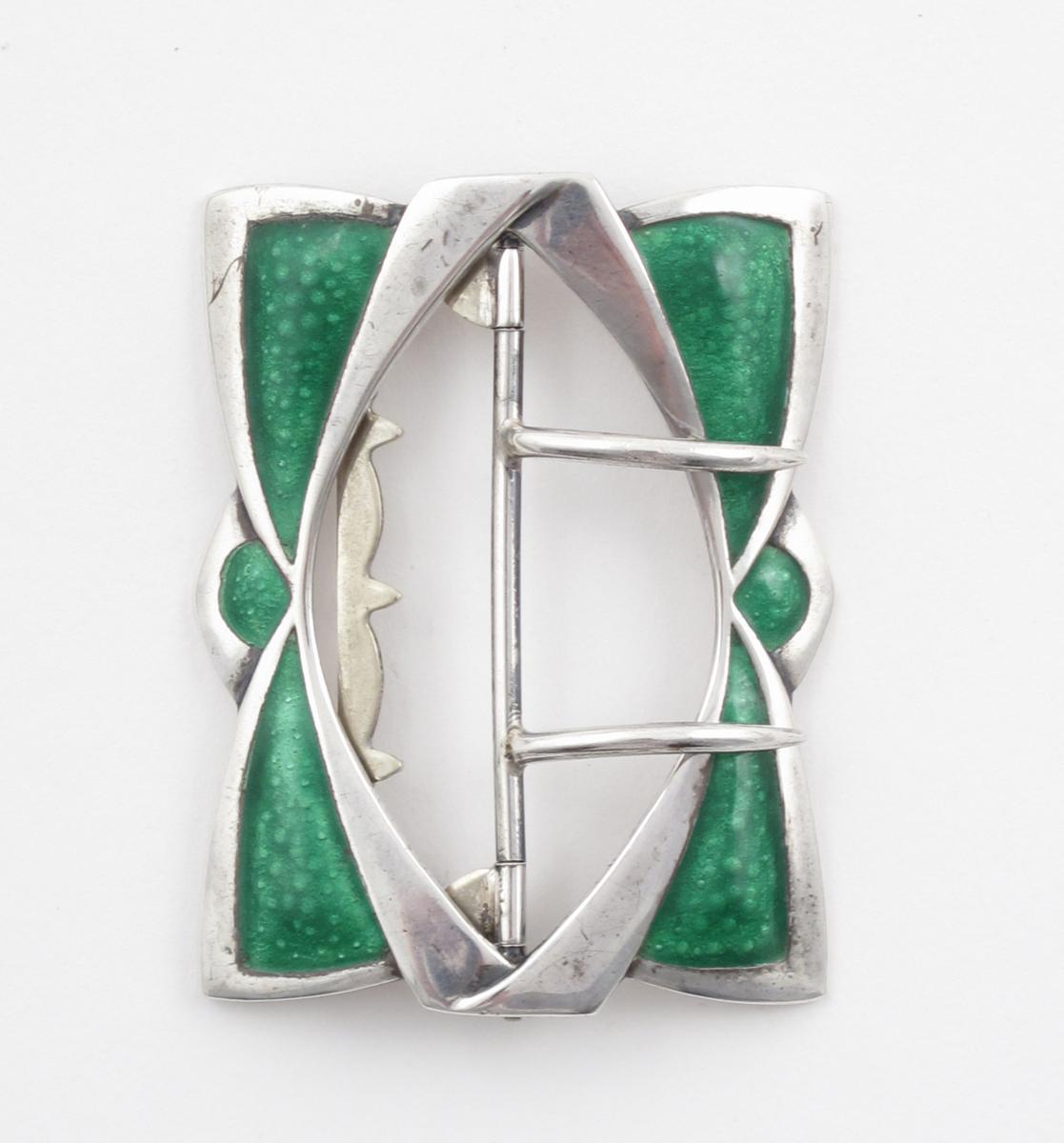 A silver and enamel buckle, pierced rectangular form, enamelled with four green panels, stamped JW