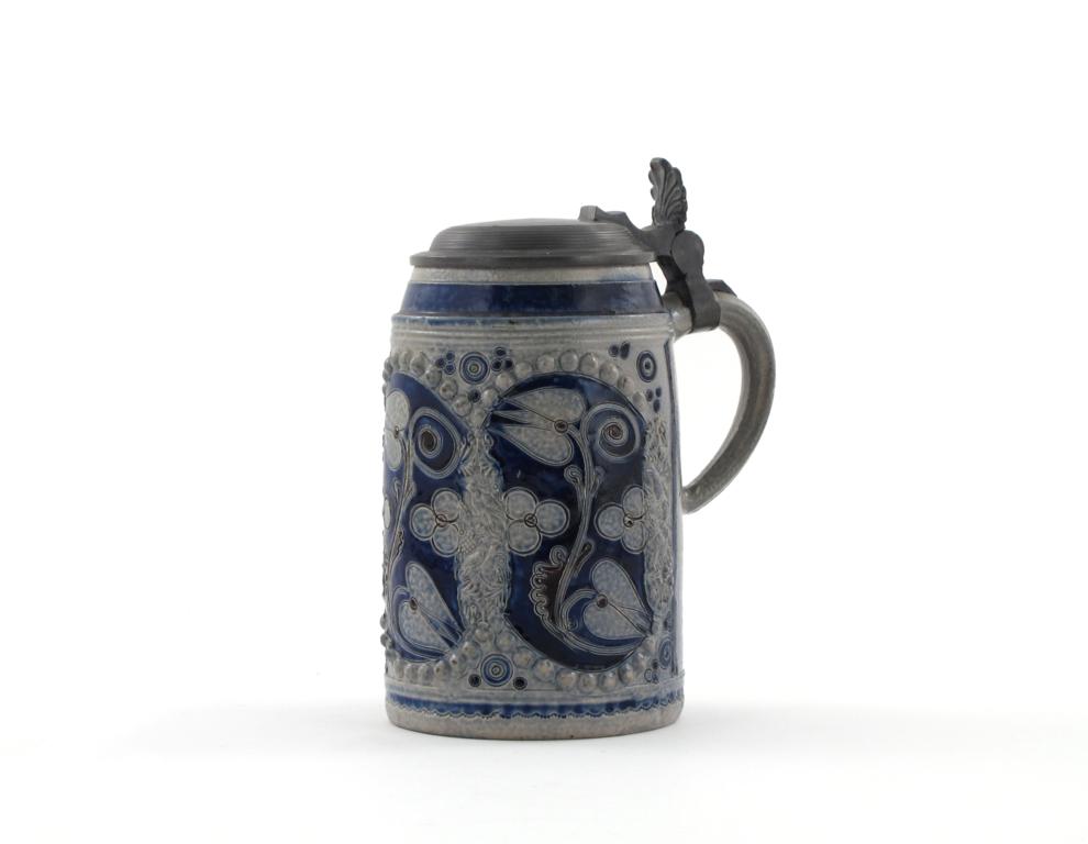 A Westerwald stoneware tankard early 18th century, incised with three panels of a tulip design,