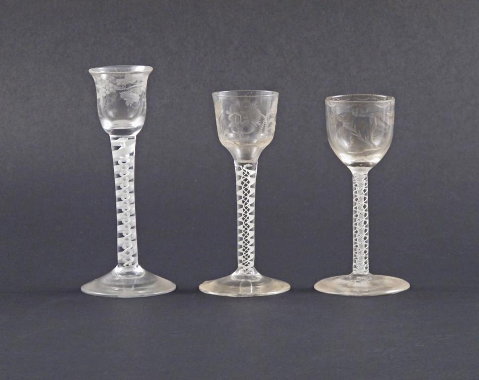 Three small glasses 18th century, variously engraved with a rose, fruiting grapevine, and other