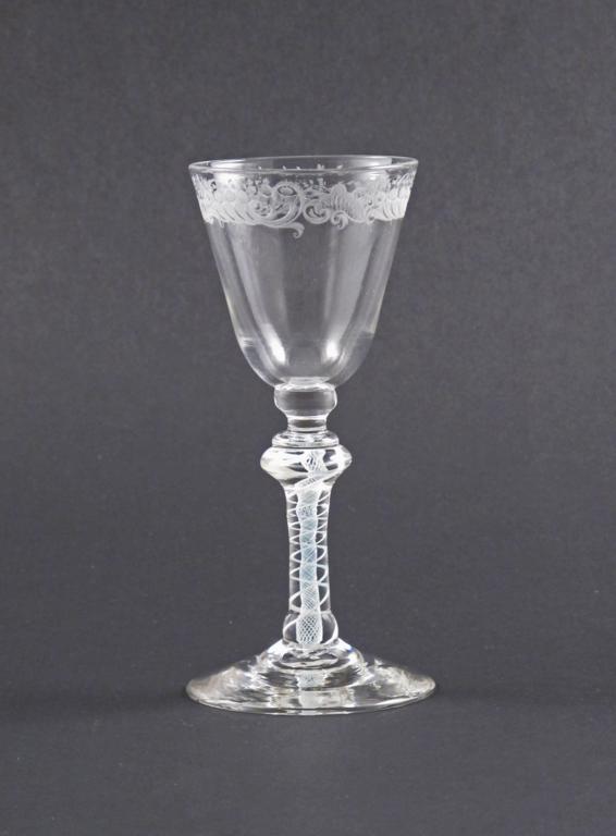 A large wine glass c.1760, the round funnel bowl engraved with rococo scrolls and small flowerheads,