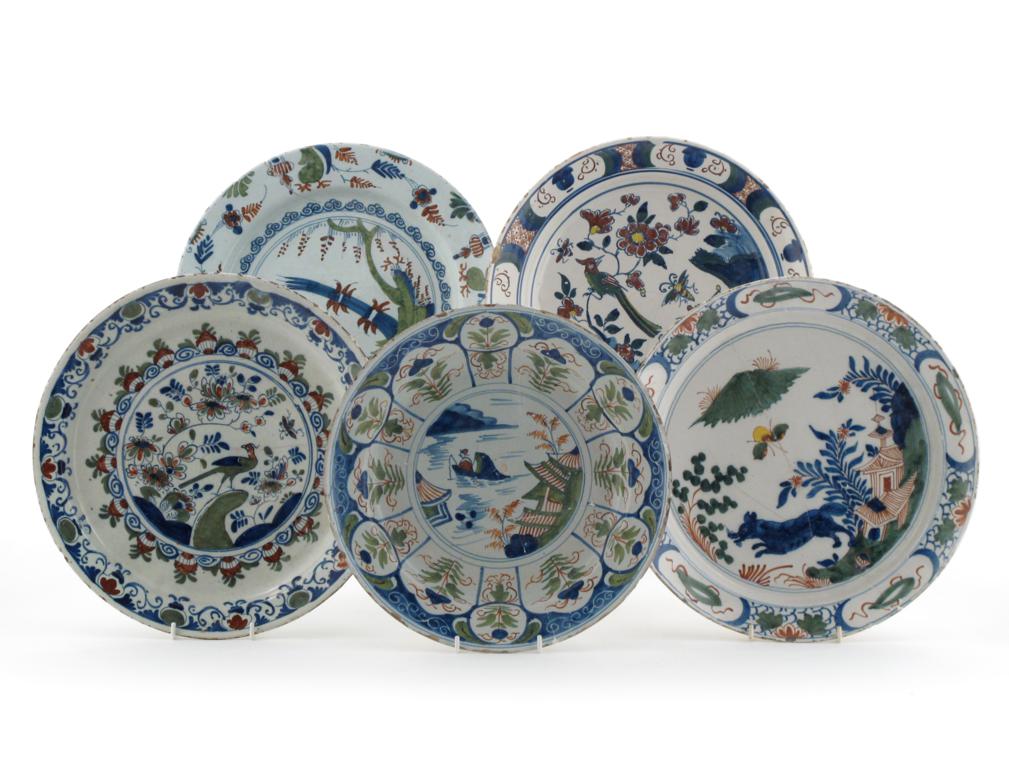 Five large delftware dishes 18th century, all decorated in shades of blue, green and red, some