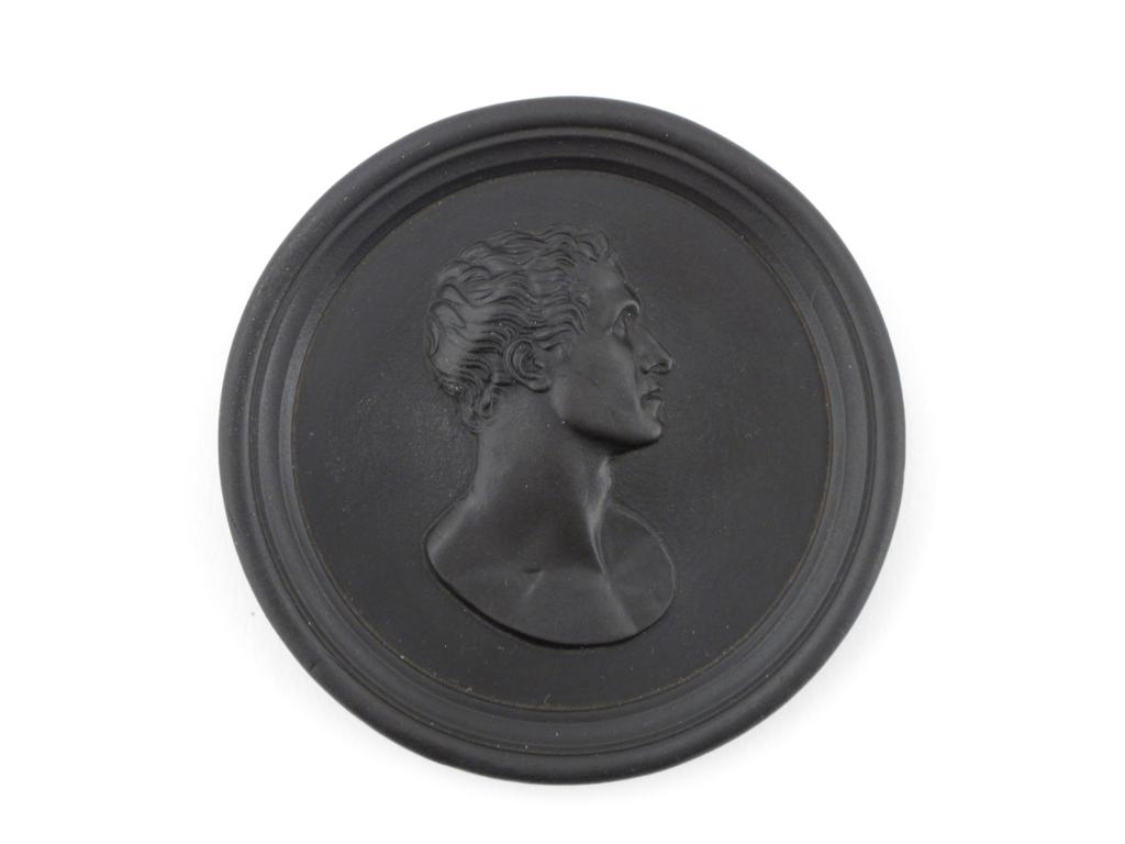 A black basalt circular plaque late 18th/early 19th century, with the profile portrait of a man